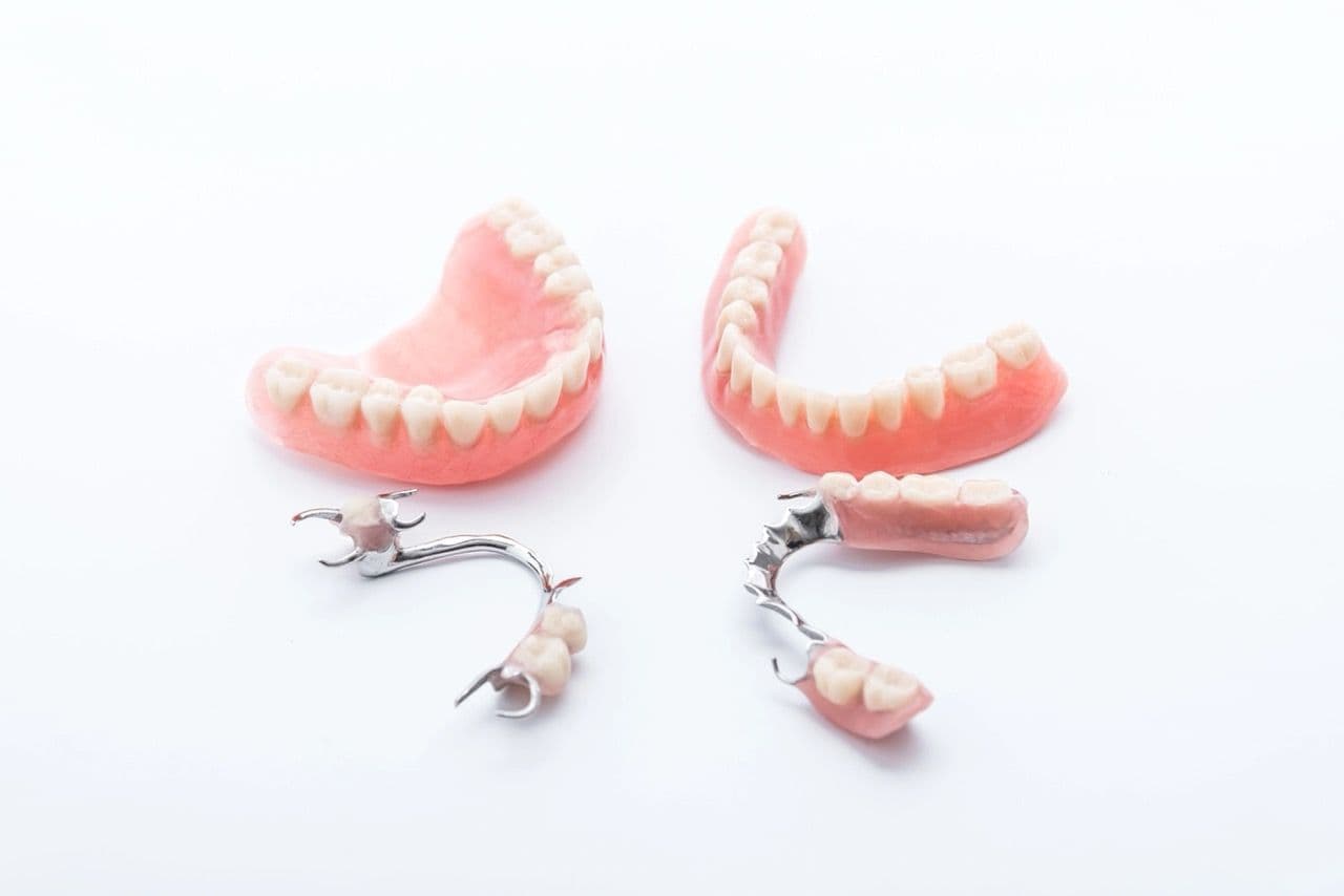 Photo of full and partial dentures on a white surface
