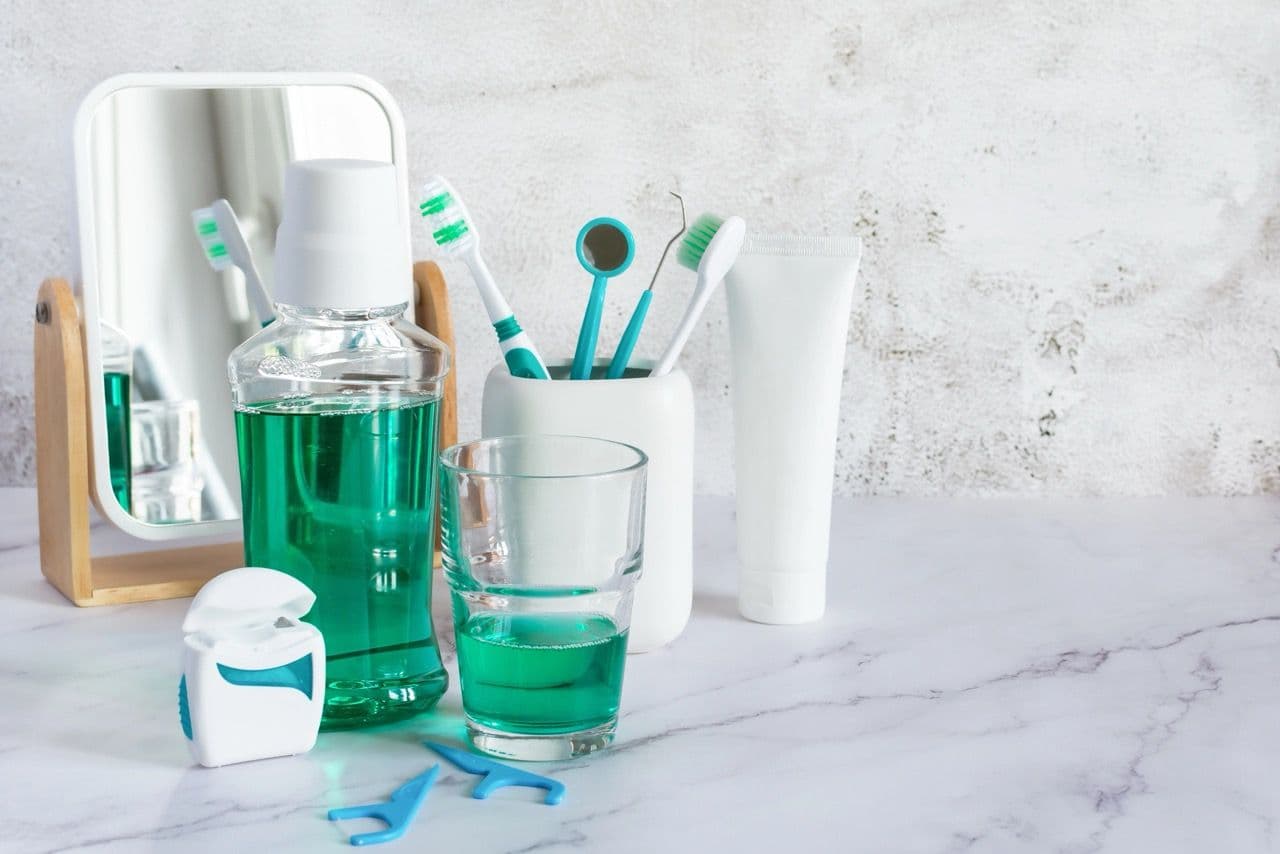 A group of teeth cleaning products including floss, mouthwash, toothbrush, etc.