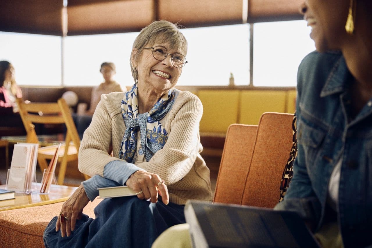 couple sitting on a couch holding hands and smiling